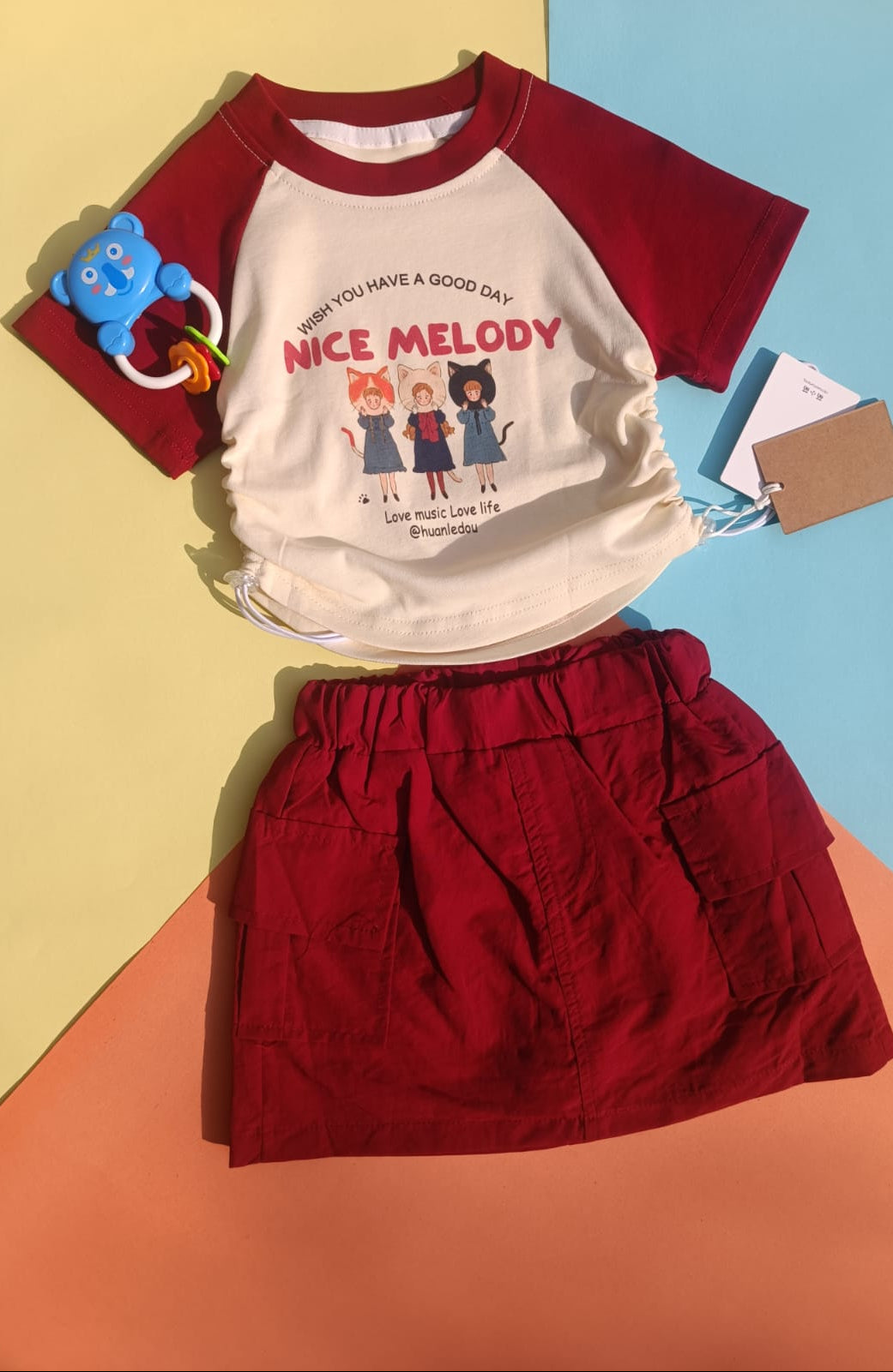 Children's outfit with red and white shirt and red skirt on a colorful background