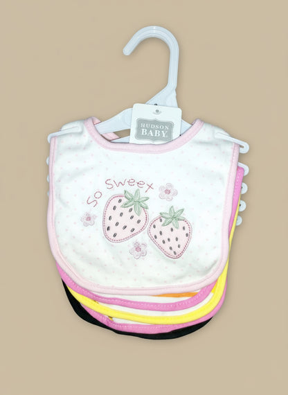 Baby bib with strawberry design on a hanger against a textured surface