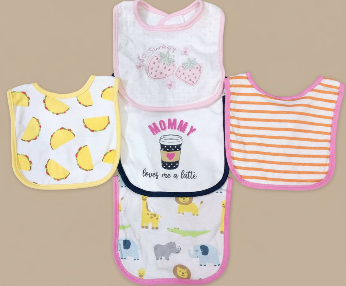 Four baby bibs with different patterns on a textured surface