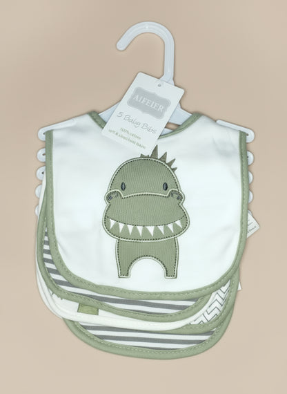 Set of baby bibs with a dinosaur design on a hanger against a textured background