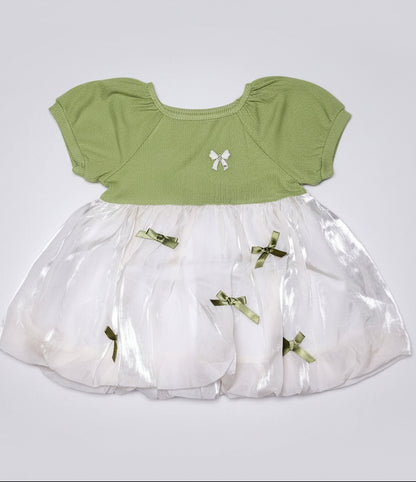 Green top and white skirt with decorative elements on a black background