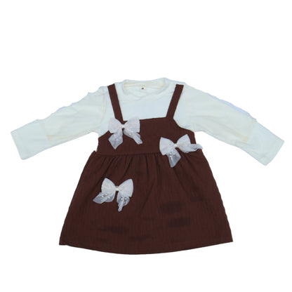 Brown and white outfit with butterfly details on a light  background