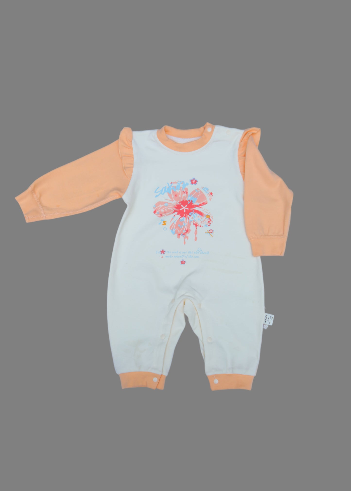 Light green baby romper with orange trim on a light blue background