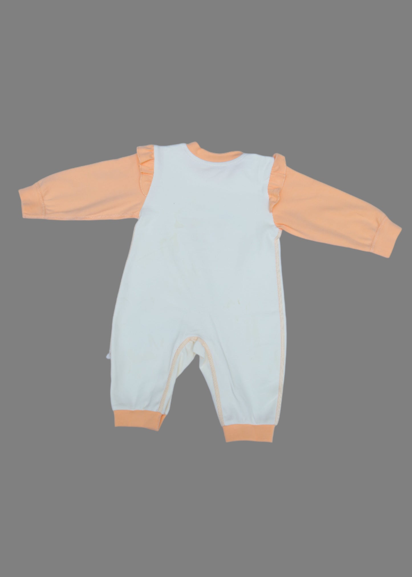 Light green and orange baby outfit on a light blue background