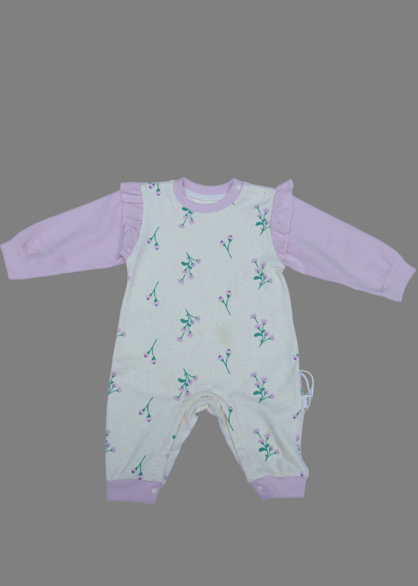 Baby romper with pink trim on a white surface
