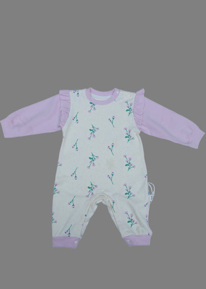 Baby romper with pink trim on a white surface