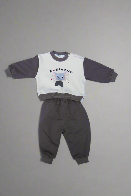 Children's outfit with a white shirt and gray pants on a light blue surface.