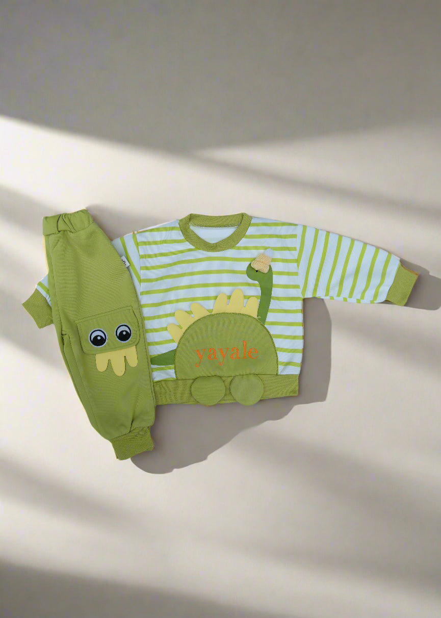 Green dinosaur-themed children's outfit on a light blue surface