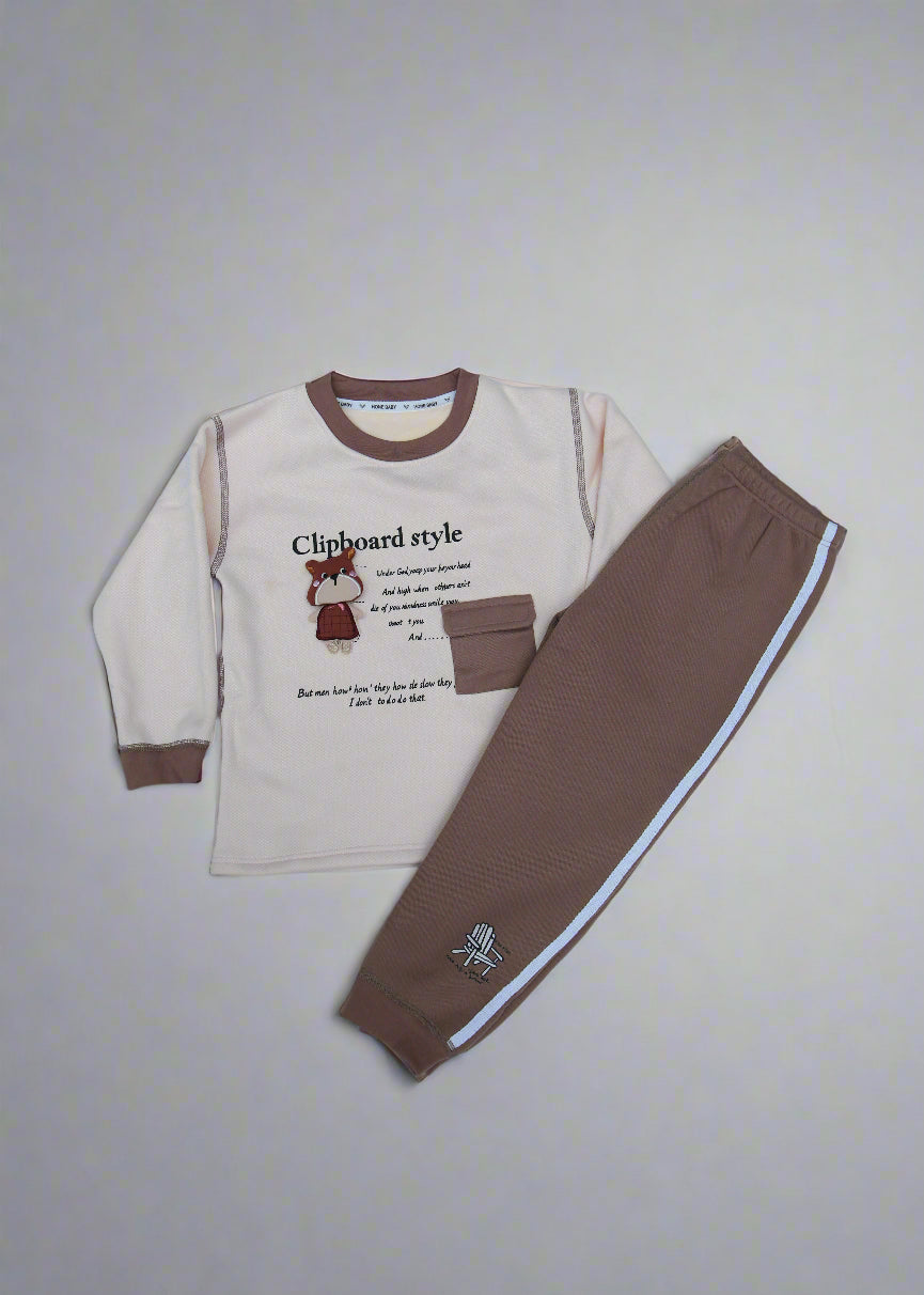 Children's outfit with beige top and brown pants on a light blue surface.