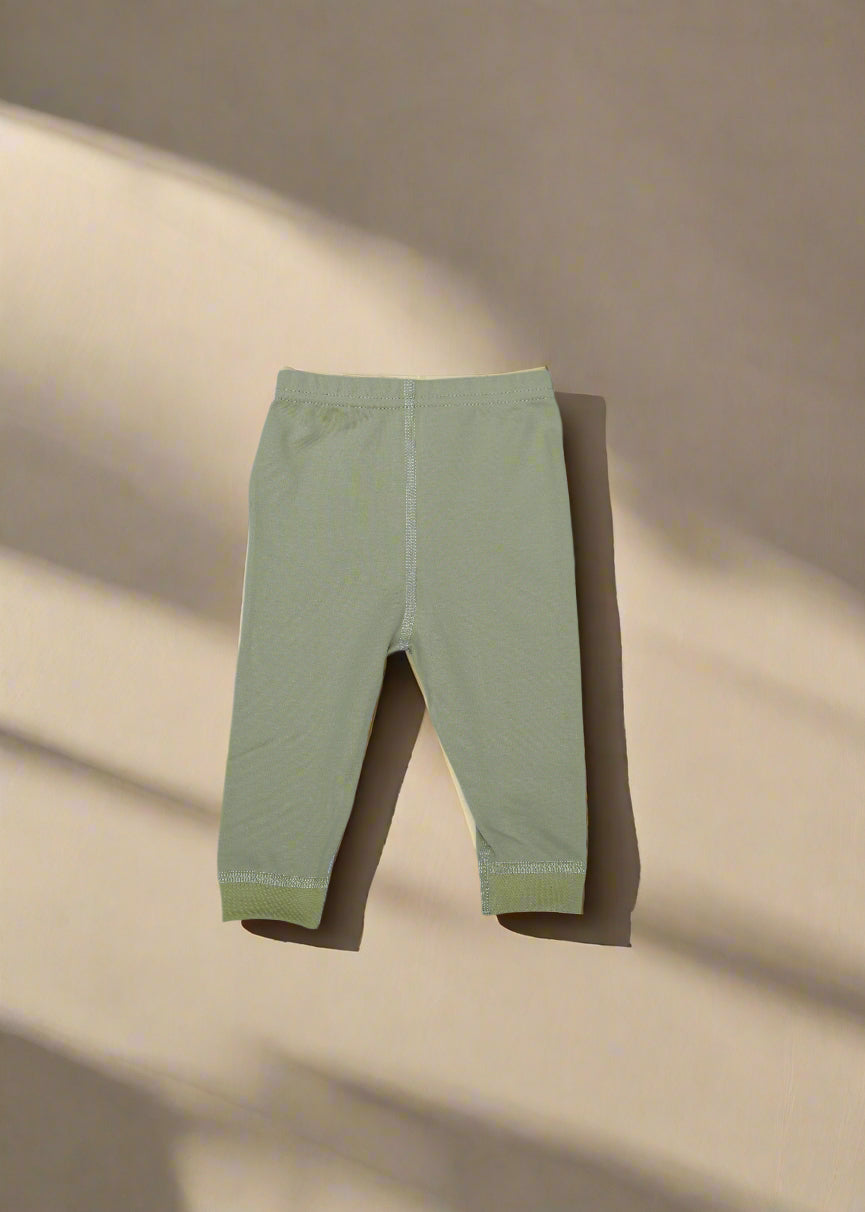 Light green pants on a light blue fabric background