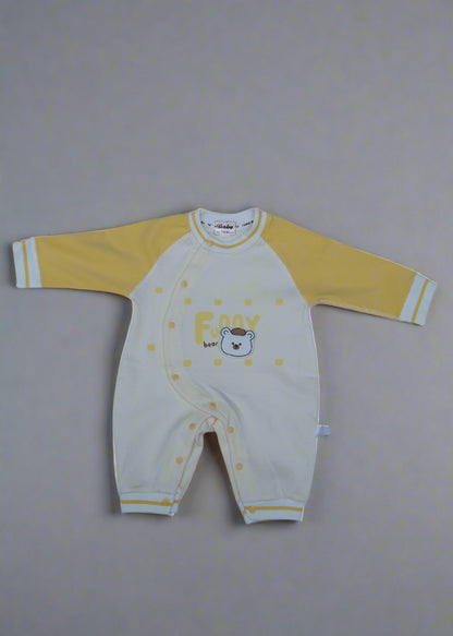 Yellow and white baby outfit with bear design on a light blue background