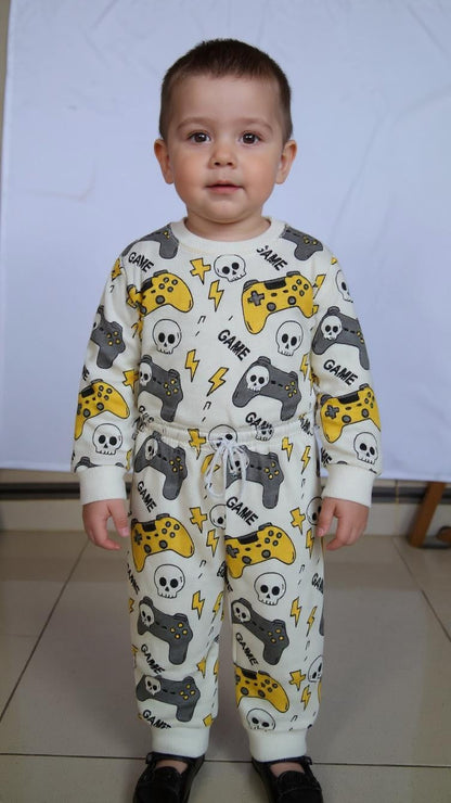 Child wearing a pajama with game-themed print on a plain background