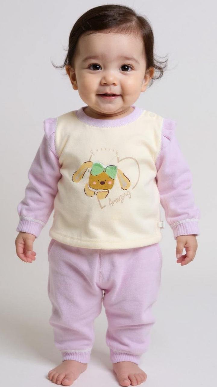 Baby wearing a pink and yellow outfit with a cartoon character on a white background