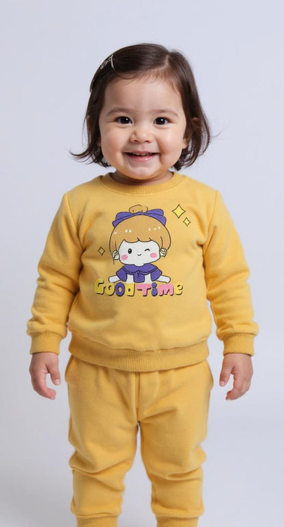 Child wearing a yellow outfit with a cartoon character on a plain background