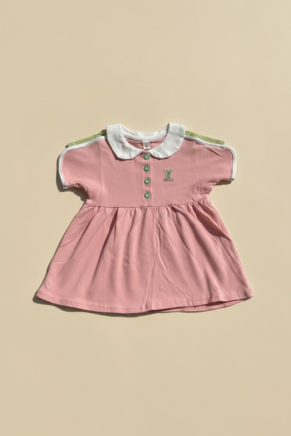 Pink dress with white collar on a gray surface