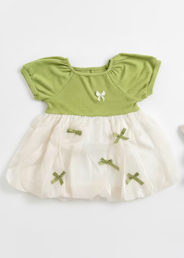Green top and white skirt set with decorative bows on a light background