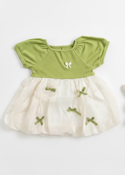 Green top and white skirt set with decorative bows on a light background