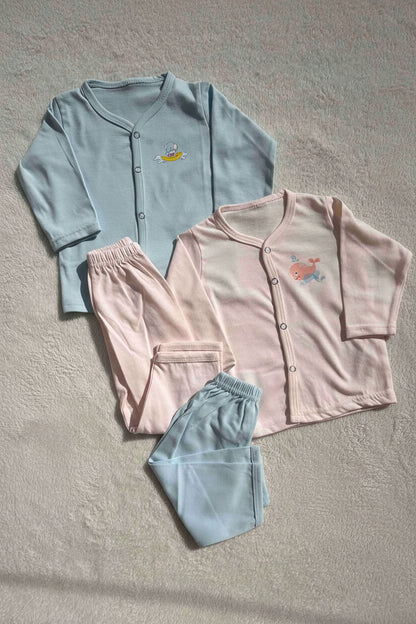 Light blue and pink pajama sets with a plush toy and flower on a neutral background