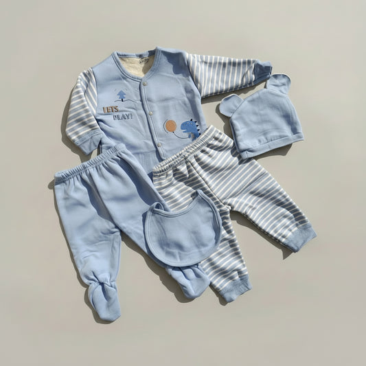 Baby clothing set with blue outfit, pants, hat, and bib on a beige background