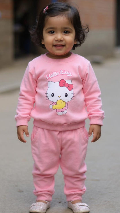 Child wearing a pink Hello Kitty outfit standing on a pavement.