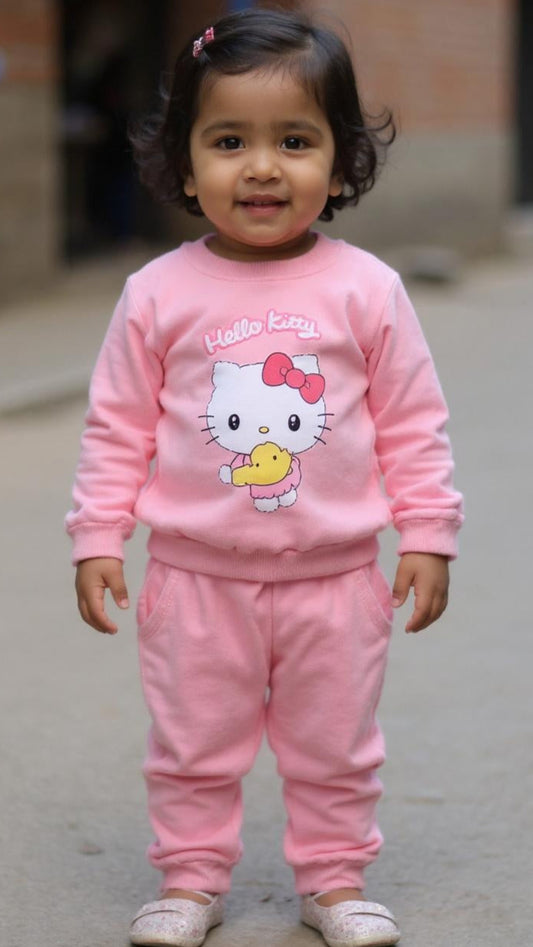Child wearing a pink Hello Kitty outfit standing on a pavement.