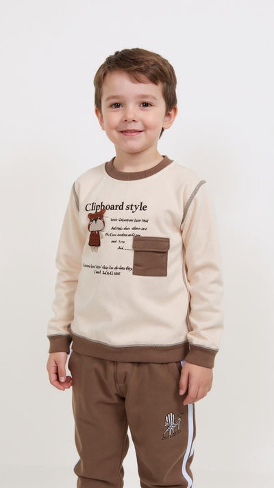 Child wearing a beige and brown outfit with text and graphics on a white background