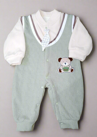 Baby outfit with green vest and white shirt on a patterned yellow background