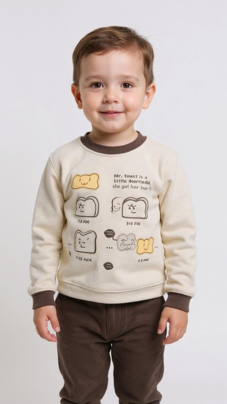 Child wearing a cream sweater with cartoon designs on a white background