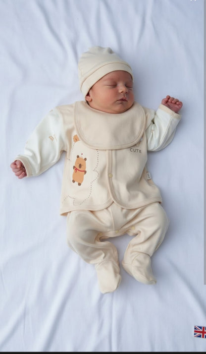 Newborn baby in a cream outfit with bear design on a white background