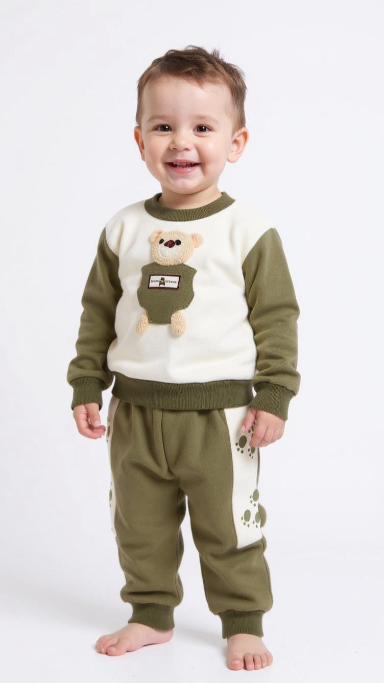 Child wearing a green and beige outfit with a bear design on a white background